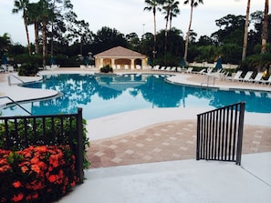 A swimming pool with lounge chairs and a gazebo. - Castle Pines Efficiency Unit (Port St Lucie)