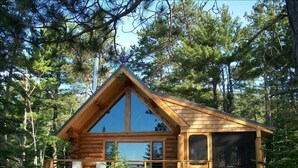A wooden cabin with a balcony, surrounded by trees. - Tettegouche Log Cabin Lake Superior views, Sauna, 4 state parks, snowshoe trails (Silver Bay)