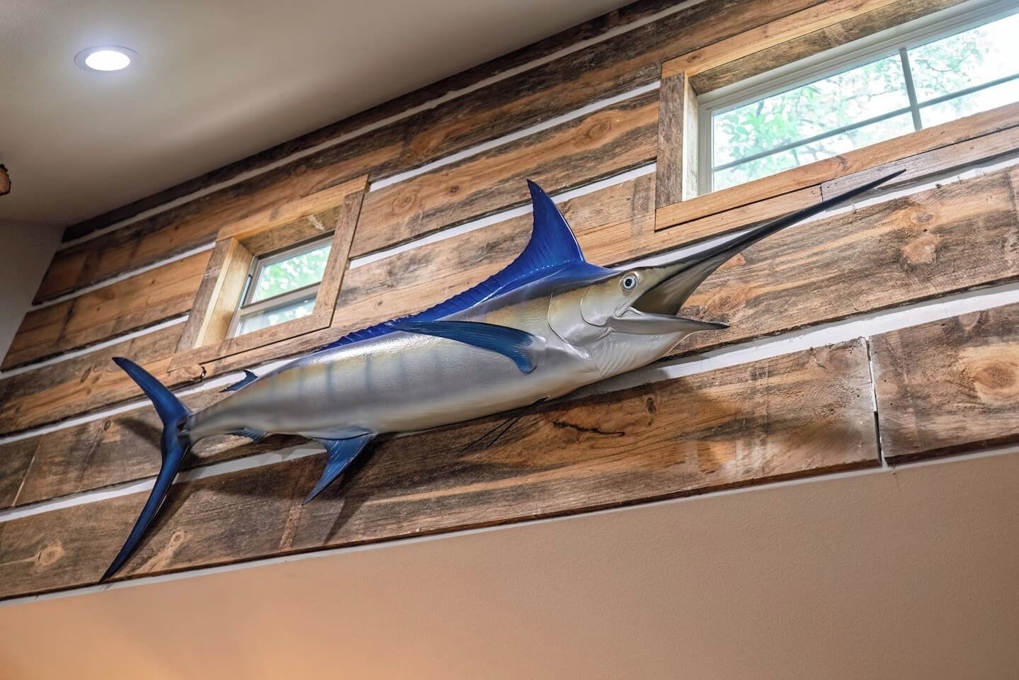A wall with a large fish decoration and wooden paneling.