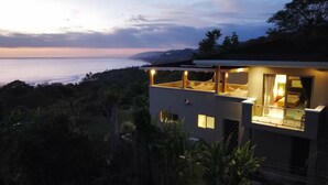 Un bâtiment moderne à deux étages doté d’un balcon donnant sur un paysage côtier.