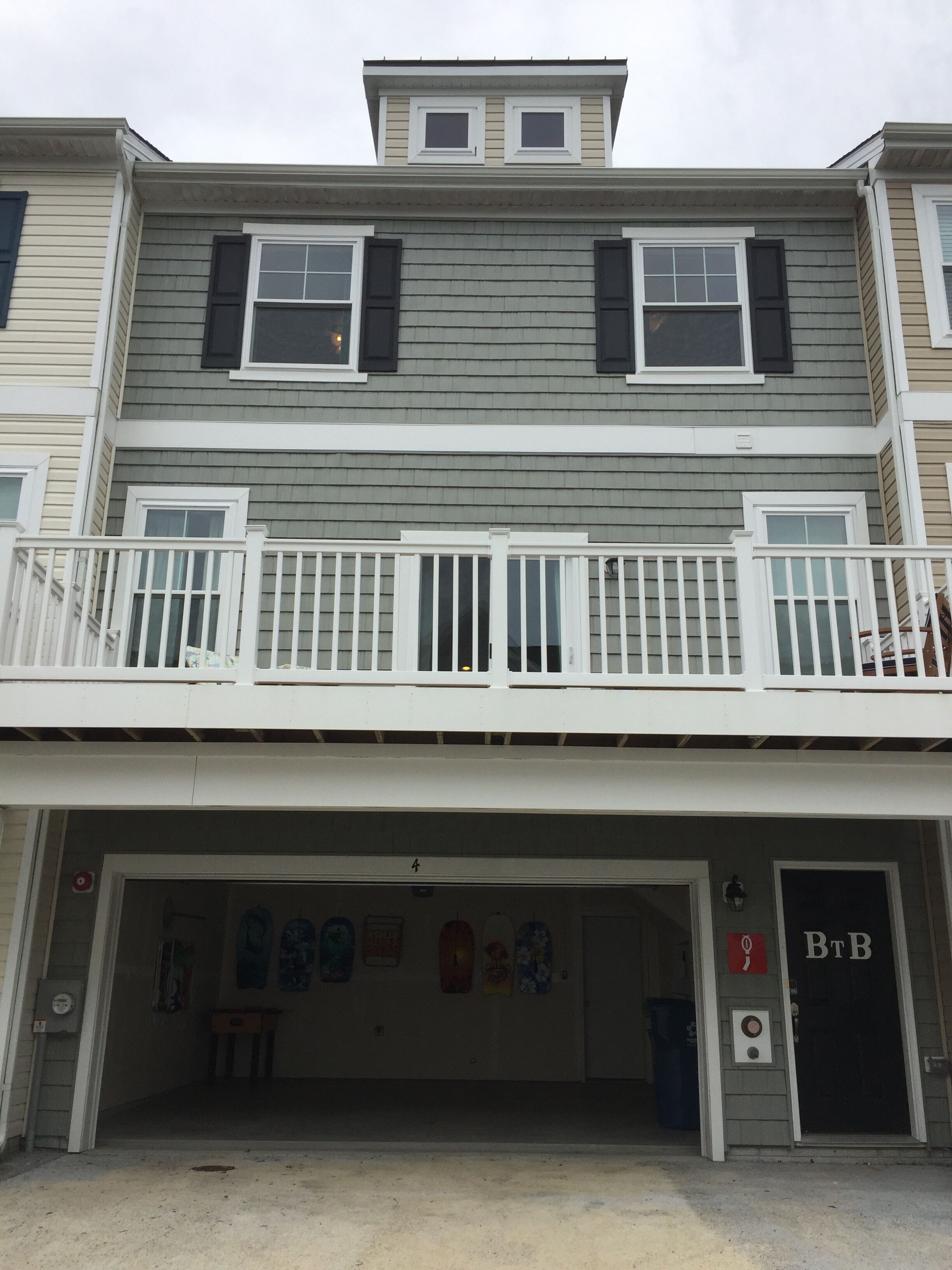A two-story building with a garage entrance, a balcony, and a sign that reads "B&B".