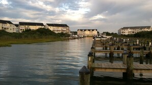A waterfront property with a wooden dock leading to a marina, surrounded by residential buildings. - Gorgeous Seaside Village On Golf Course Rd In Sought After West OC (Ocean City)
