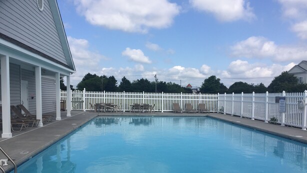 A swimming pool with lounge chairs and a white fence. - Gorgeous Seaside Village On Golf Course Rd In Sought After West OC (Ocean City)