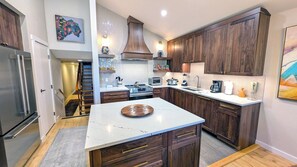 Una cocina moderna con armarios de madera, encimera de mármol y una isla central.