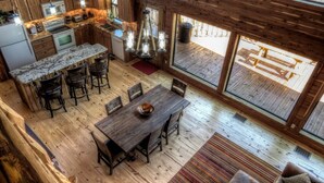 Una cocina amplia con armarios de madera, encimera de granito y comedor con mesa y sillas de madera.