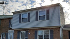A two-story brick building with white siding and dark shutters, featuring a front door and two windows on the upper floor. - Cozy and Spacious Lexington stay (Lexington)