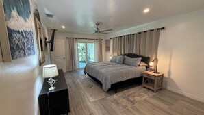 A bedroom with a bed, bedside tables, a desk, a ceiling fan, and a view of the outdoors. - Sleeps 10 - Available Year Round -  Huge Private Home (Sanibel)