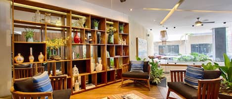 Uma sala de estar moderna com uma grande estante de madeira, assentos confortáveis e vista para o exterior.