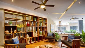 A spacious living area with wooden furniture, a large bookshelf, and a view of the street. - Modern Mexican 1BR | 2 Pool, Gym & Balcony (Puerto Vallarta)