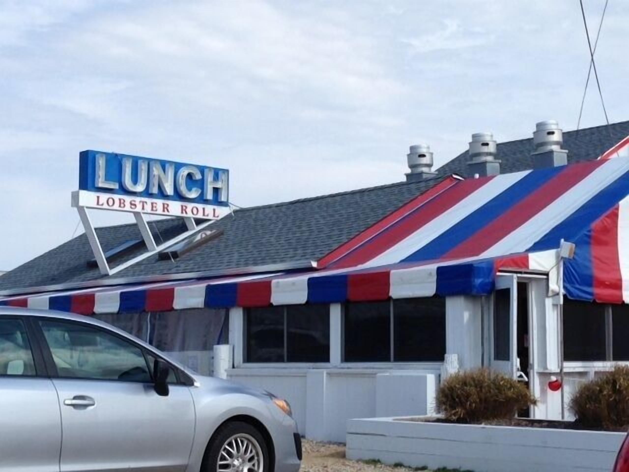 A building with a sign that reads "LUNCH LOBSTER ROLL".