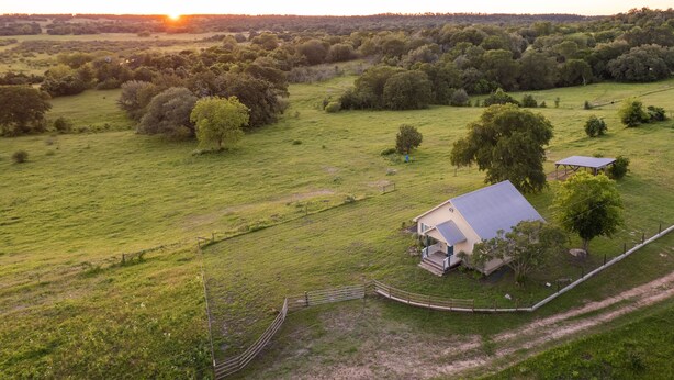 Une propriété rurale comprenant une grande maison, des espaces clôturés et un paysage environnant.