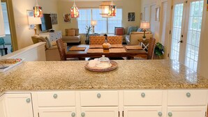 Amplia sala de estar con mesa de comedor, asientos cómodos y una encimera de cocina.