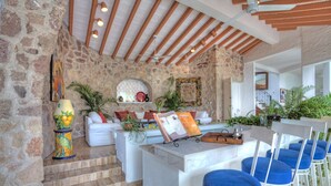 Un intérieur chaleureux avec un mur en pierre, des meubles blancs et un plafond en bois.
