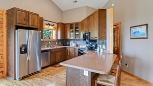 Una cocina moderna con armarios de madera, electrodomésticos de acero inoxidable y encimera de granito.