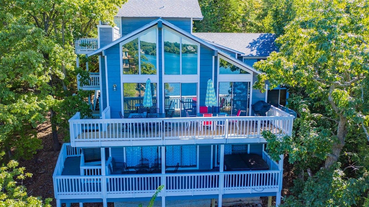A two-story house with a balcony and large windows.
