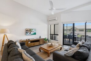 Una sala moderna con un sofá, una mesa de centro y un cuadro en la pared.