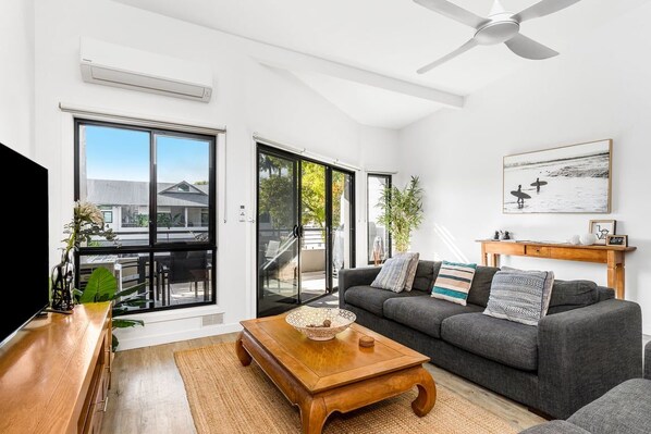 A modern living room with a sofa, coffee table, and a television.