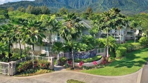 Et resort med villaer, omgivet af frodig vegetation og bjerge.