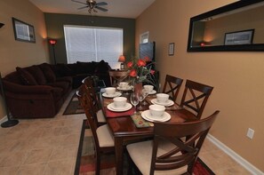 Guests can dine in comfort with a table set for four, surrounded by a warm atmosphere and natural light.