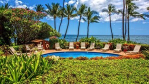 A poolside area with lounge chairs and a view of the ocean. - Oceanfront Kealia 101 Kihei Condo  Dramatic Views Steps from Pool and Beach (Kihei)