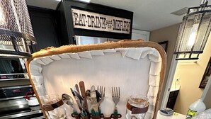 A wicker basket with a sign above it that reads "EAT, DRINK, and MERRY".