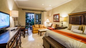 Una habitación de hotel con cama, escritorio con televisor, sofá y sillón.