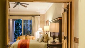 Habitación de hotel con una cama grande, una zona de estar con lámpara, chimenea y bañera.