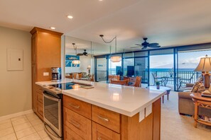Enjoy meals and casual gatherings in this spacious kitchen and dining area with a large island and scenic ocean views.