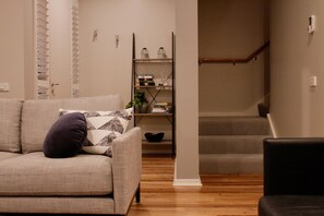 Relax in this inviting living space with a sofa, shelving, and a staircase leading to additional living areas.