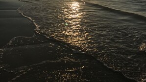 A beach with the sun reflecting on the water. - Emerald By the Sea #813, Beautiful Gulf View, Luxury Hi Rise 2 Bedroom Condo (Galveston)