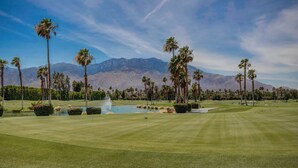 A golf course with well-manicured grass, palm trees, and a mountain backdrop. - Desert Princess Cc And Resort, On Golf Course, W/ Mountain Views (Cathedral City)