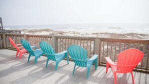 A wooden deck with colorful Adirondack chairs facing a beach. - Perfect Gulf Front Beach House *Beach Club Amenities*The Best of Both Worlds! (Gulf Shores)