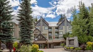 A multi-story lodge with a stone facade, balconies, and a landscaped entrance. - Mountain-Side 3Br/2Ba - HotTub/Views/Free Parking (Whistler)