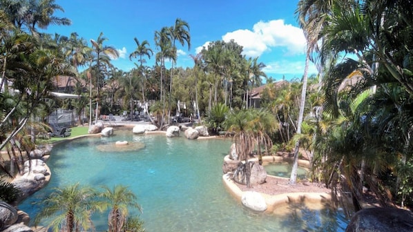 Relax by the resort's inviting pool surrounded by lush tropical vegetation and a small waterfall.