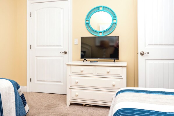 A bedroom with a white dresser, a television on top, a mirror above it, and two doors. - Beach Therapy - Oceanfront!! 4 BR / 3 BA Enjoy the views from Master Bedroom! (Topsail Beach)