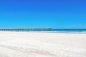 A beach with a pier extending into the ocean. - Beach Therapy - Oceanfront!! 4 BR / 3 BA Enjoy the views from Master Bedroom! (Topsail Beach)