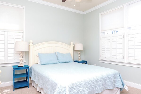 A bedroom with a bed, two nightstands, a window with shutters, and a ceiling light. - Beach Therapy - Oceanfront!! 4 BR / 3 BA Enjoy the views from Master Bedroom! (Topsail Beach)