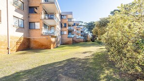 Un edificio de apartamentos moderno con varios balcones y un césped bien cuidado.