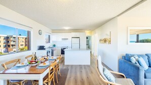 A modern apartment with a dining area, kitchen, and living space. - Intrepid, 15 3 Intrepid Close - right on the beachfront and WiFi (Nelson Bay)