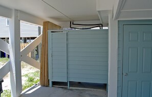 Un espacio al aire libre cubierto con una puerta azul claro y una barandilla blanca.