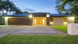 Een modern huis met garage, een voortuin met trap en een verzorgd gazon.