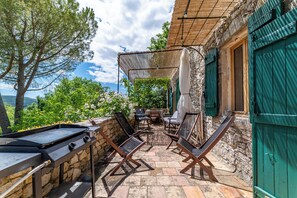 A patio with a grill, outdoor furniture, and a view of the landscape. - Stone farmhouse with pool (Saint-André-de-Roquepertuis)