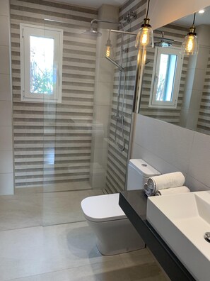 Een bad/douchecombinatie, een haardroger, handdoeken