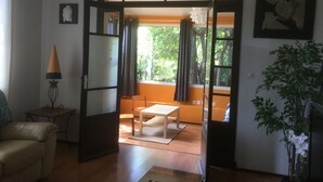 A room with a sliding door leading to an outdoor area, a sofa, a small table, a lamp, and a potted plant. - "MarViva" Air-conditioned house, 2/3 bedrooms - Private swimming pool, 5 min walk to the beach (La Seyne-Sur-Mer)