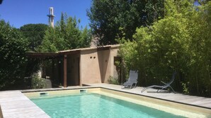 A rectangular swimming pool with clear water, surrounded by a wooden deck and shaded by trees. - "MarViva" Air-conditioned house, 2/3 bedrooms - Private swimming pool, 5 min walk to the beach (La Seyne-Sur-Mer)