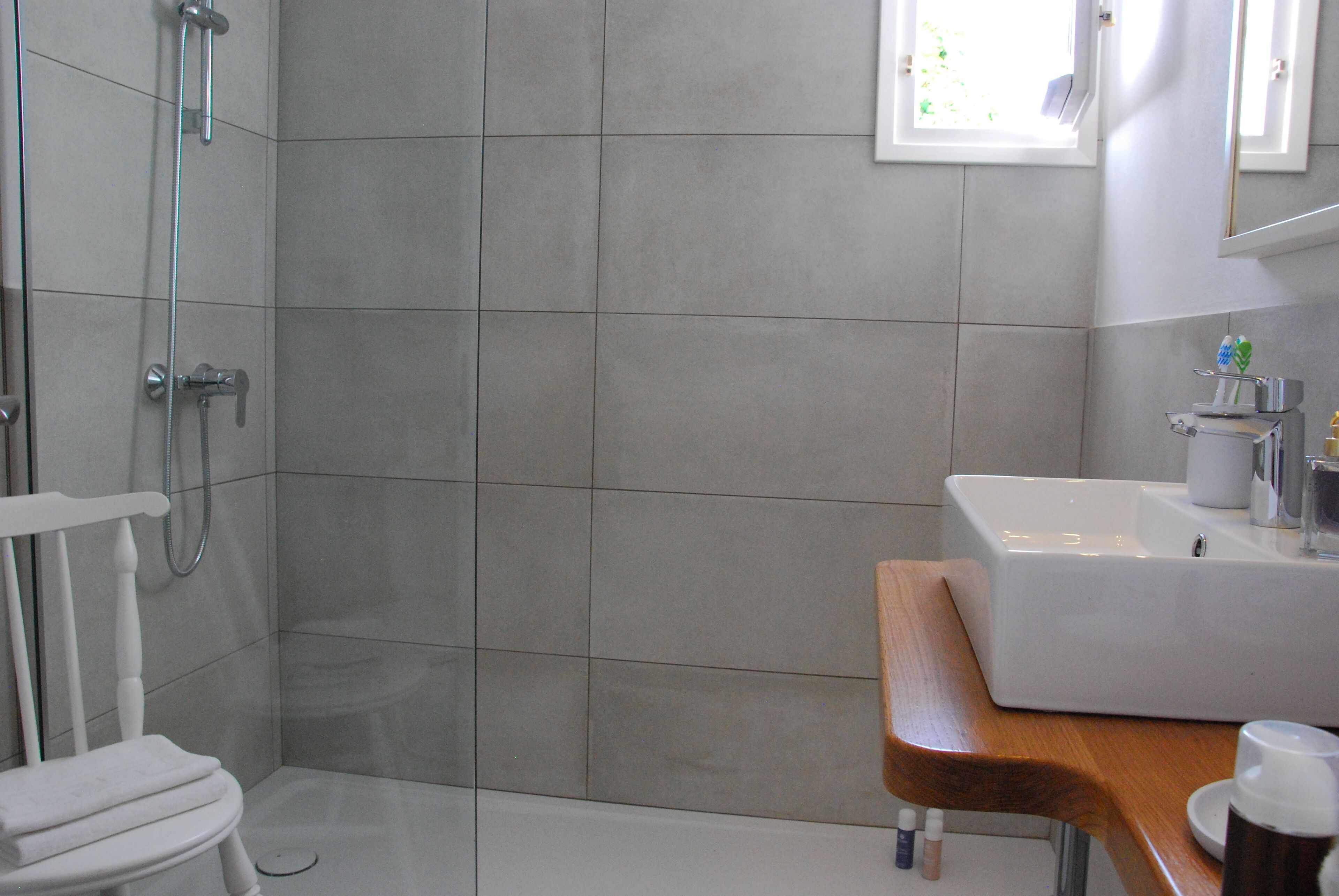A modern bathroom with a shower, toilet, and sink.