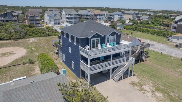 A multi-story residential building with a balcony, a garage, and a visible driveway. - 5454- Sea View - Nags Head Semi-Oceanfront | Private Pool (Nags Head)