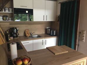 A compact kitchen with a sink, a coffee maker, a toaster, and a cutting board on the counter. - Quiet, cozy vacation home with fireplace, barbecue area and fantastic views (Hatzfeld (Eder))