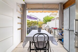 A compact kitchen with a dining area, a refrigerator, and a table with chairs.