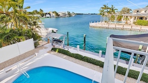 A pool area with a view of a marina and ocean. - Key Colony Beach Waterfront 6BR w/ Pool & Dock (Key Colony Beach)